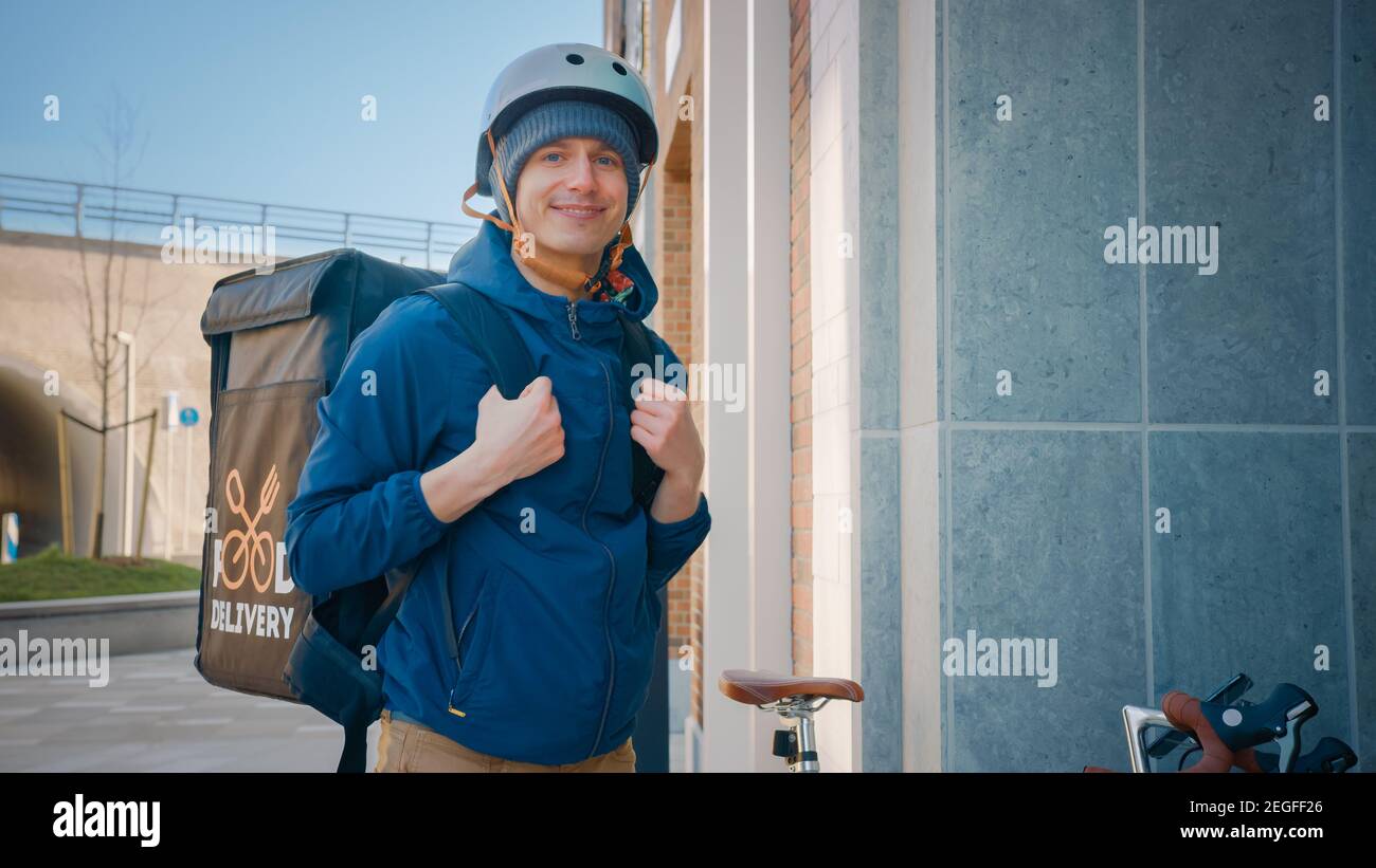 Happy Food Delivery Mann trägt Thermal Rucksack auf dem Fahrrad liefern Restaurant bestellen. Lächelnder Kurier, der Kamera anschaut. Kurier Liefert Takeaway Lunch Stockfoto
