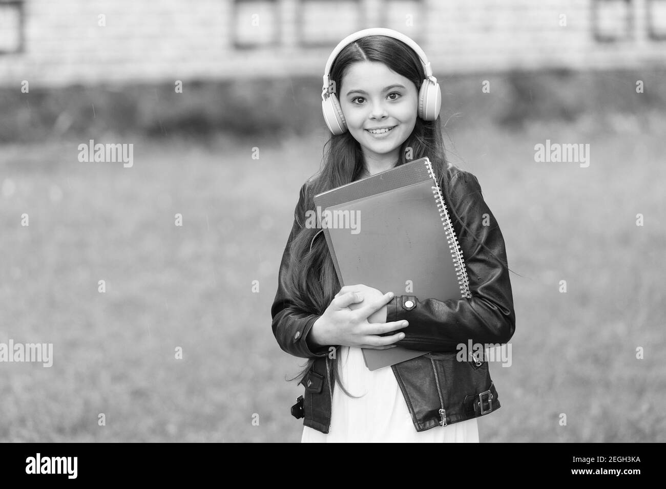 Mädchen hören Audio tragen Lehrbücher auf dem Weg zur Schule, Sprachunterricht Konzept. Stockfoto