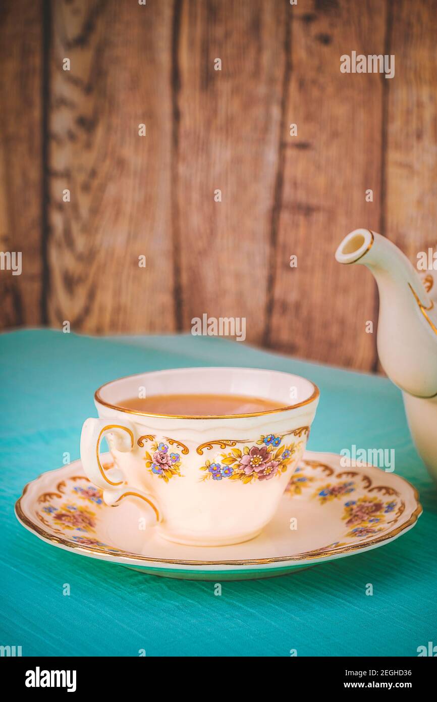 Blick auf eine Tasse Tee und ein feines porzellan Teekanne auf einem Tisch bei Sonnenuntergang Stockfoto