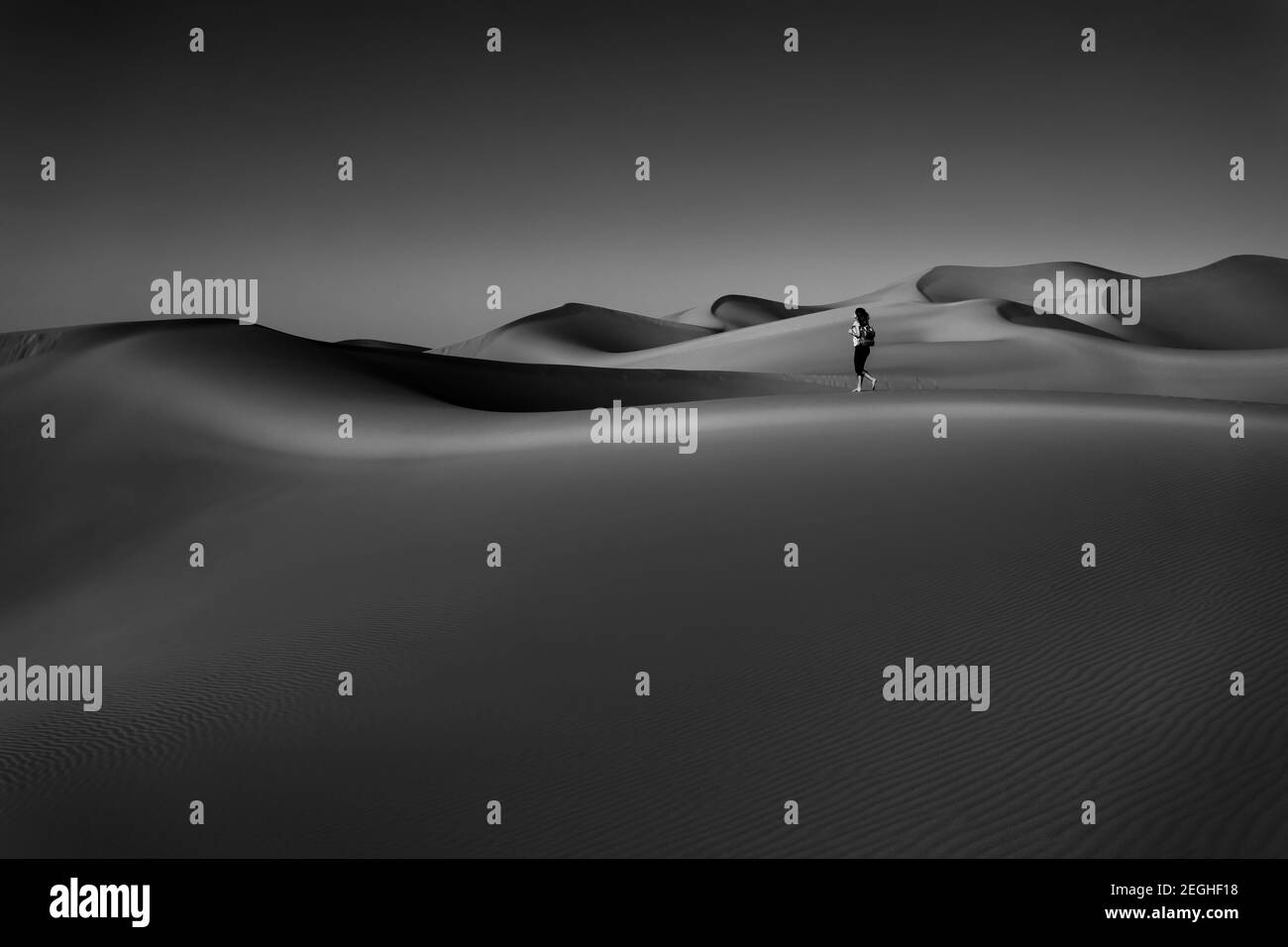 Schwarz-Weiß-Foto der schönen Wüste, durch die die Frau so frei zu Fuß. Genießen Sie die herrliche Schönheit der Liwa Wüste. Stockfoto