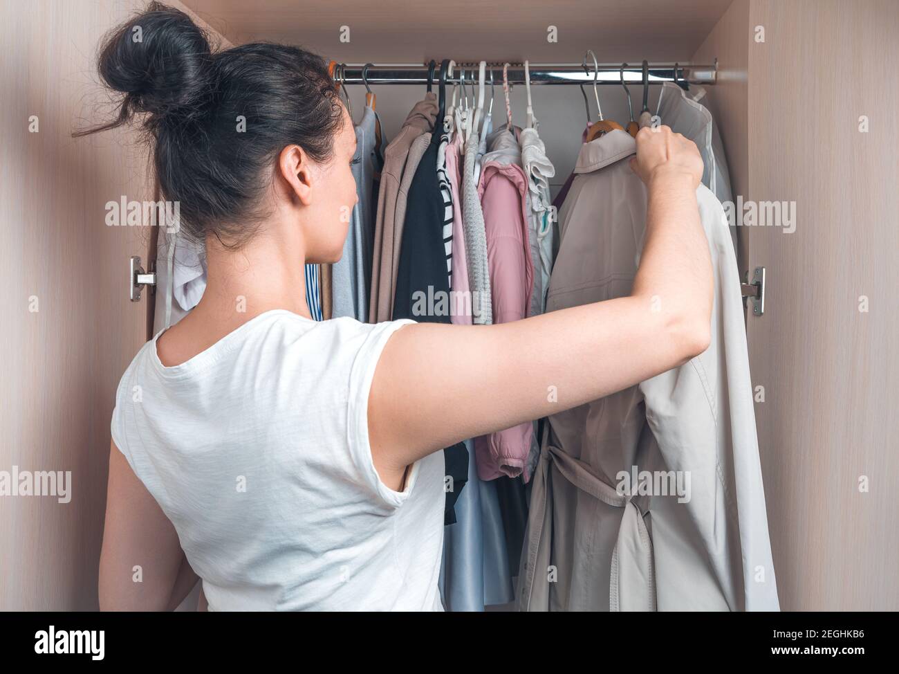 Eine Frau nimmt die Kleidung aus dem Schrank. Stockfoto