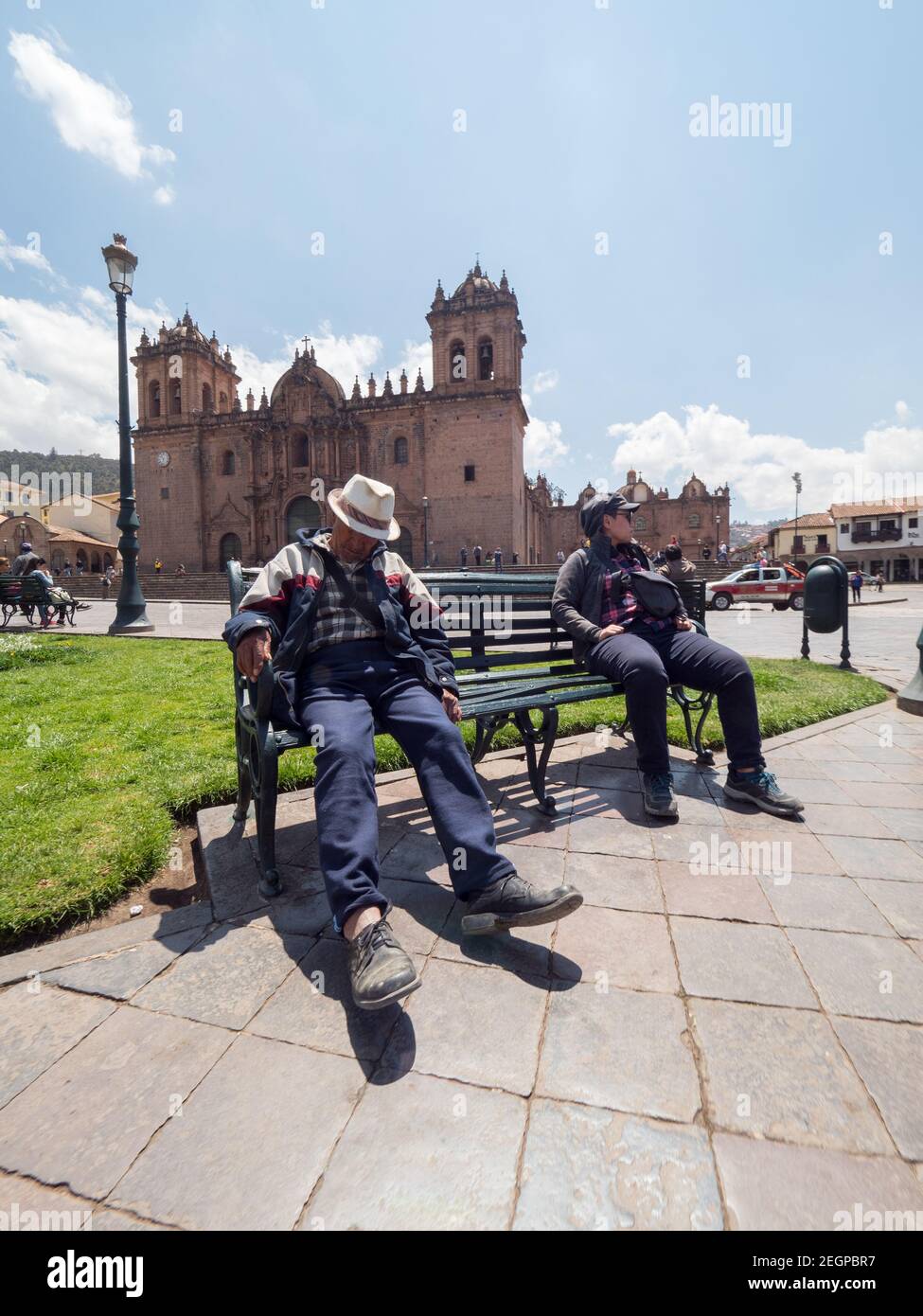 Peru, Cusco - 28. September 2019 - Mann schläft tagsüber auf der Straßenbank vor der Kirche am Hauptplatz von Cuzco Stockfoto