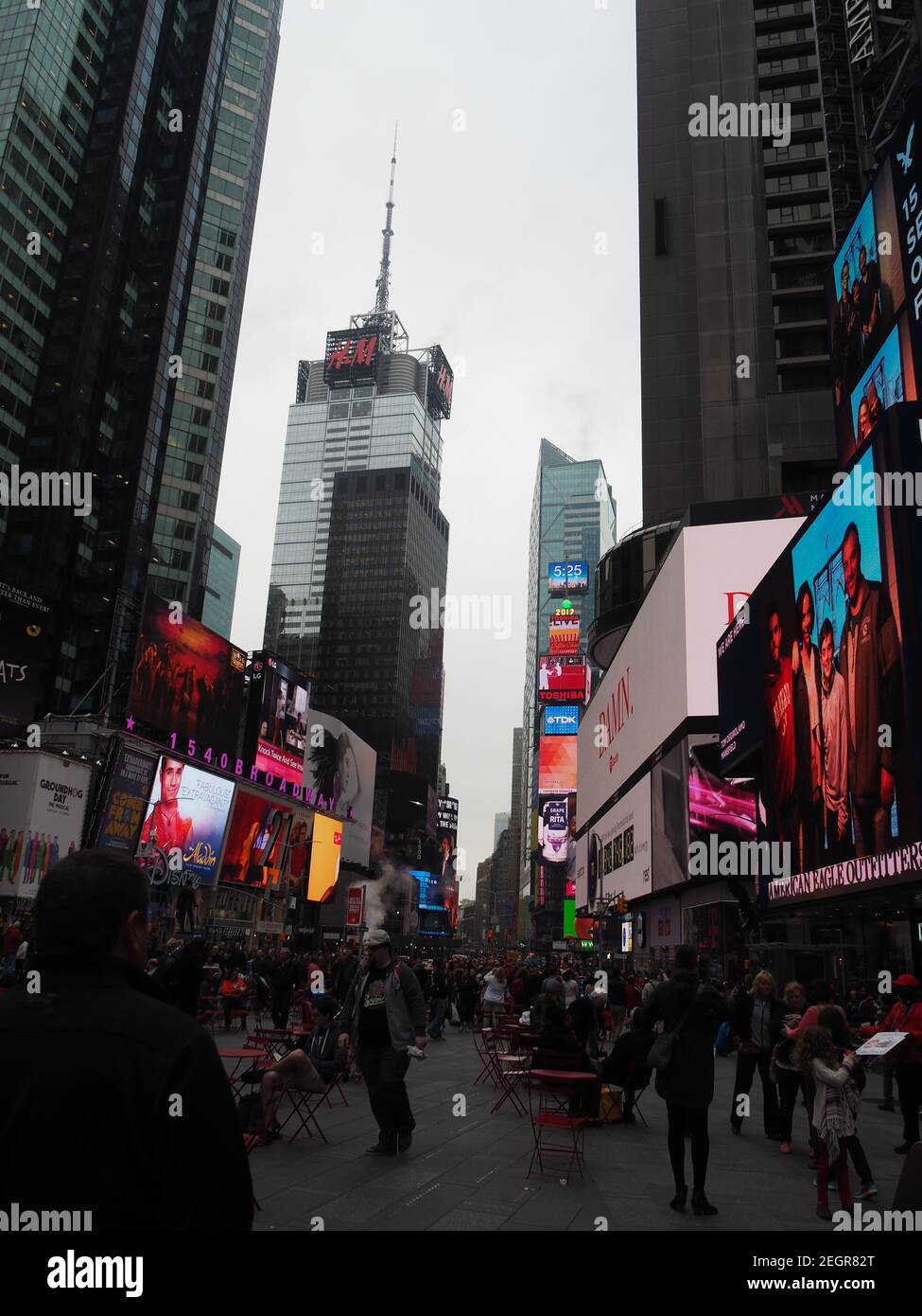 Manhattan, New York - 21. April 2017 - Wolkenkratzer im Hintergrund vom Times Square aus gesehen, bunte Anzeigen auf Displays Stockfoto