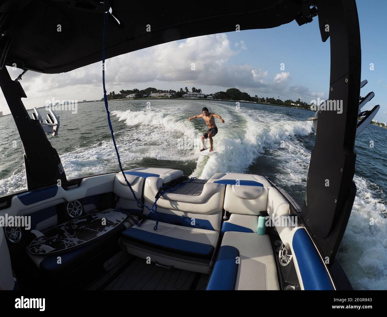 Surfer Transfer Wellenreiten hinter dem Boot, Innenraum des Bootes und Sitze im Vordergrund Stockfoto