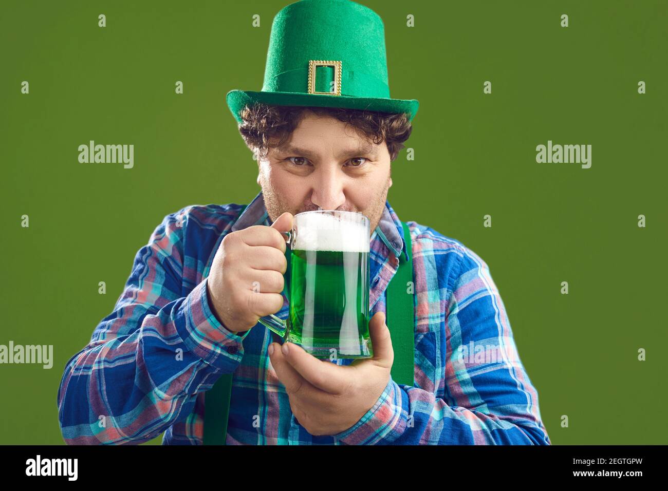 Portrait von glücklichen jungen Mann in Party Hut trinken grün Bier am St. Patrick's Day Stockfoto