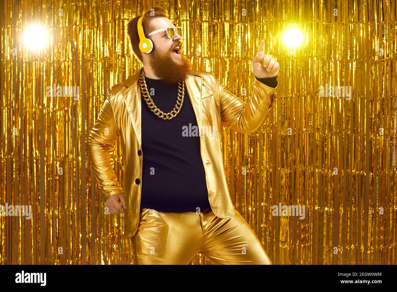 Glücklicher Mann mit Kopfhörern, der Online-Musik genießt, singt, tanzt und Spaß hat Stockfoto