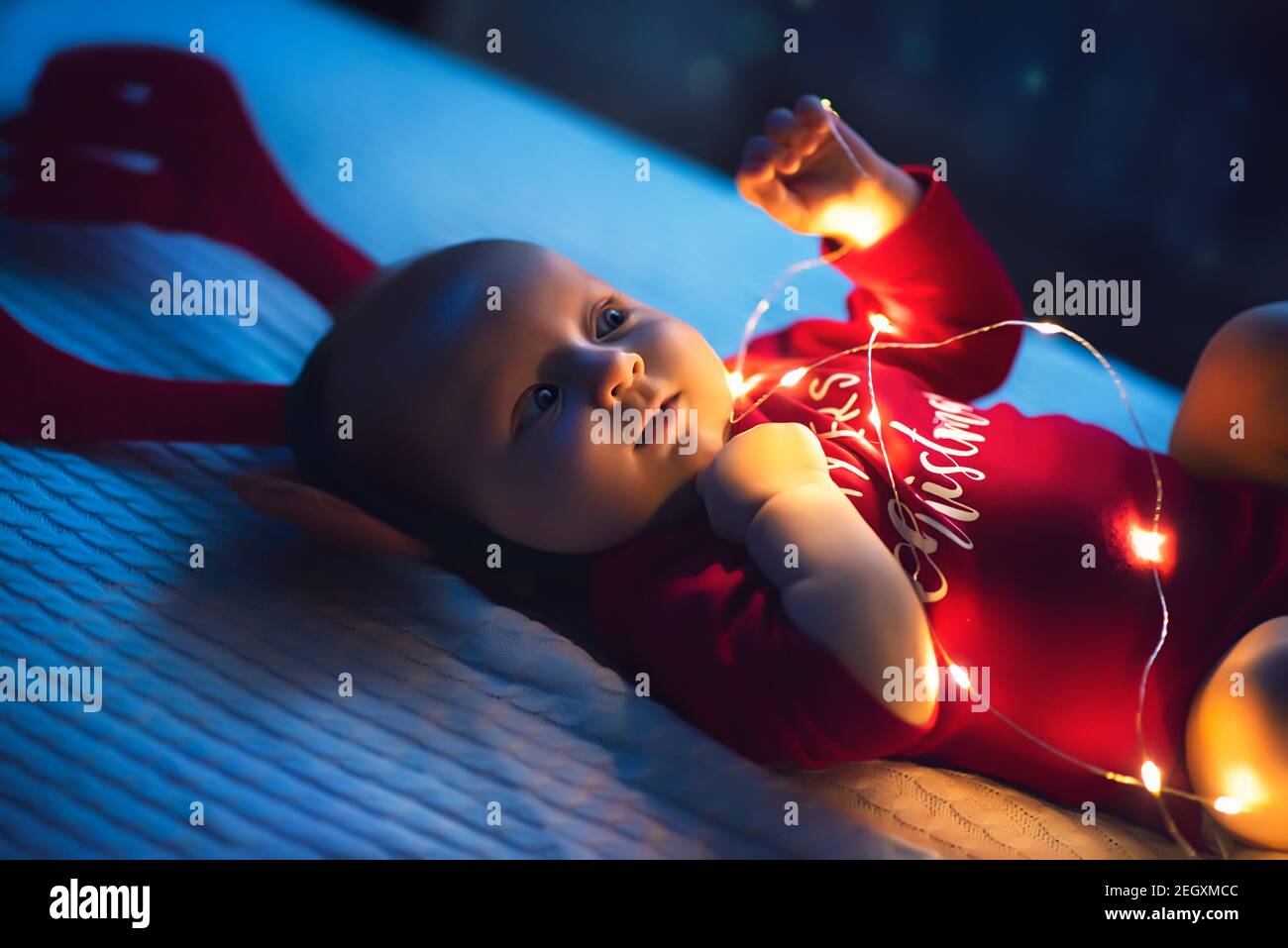 Baby Mädchen mit Santa's Crawlen mit sehr entschlossene Gesichtsausdruck. Erstes Weihnachten. Stockfoto