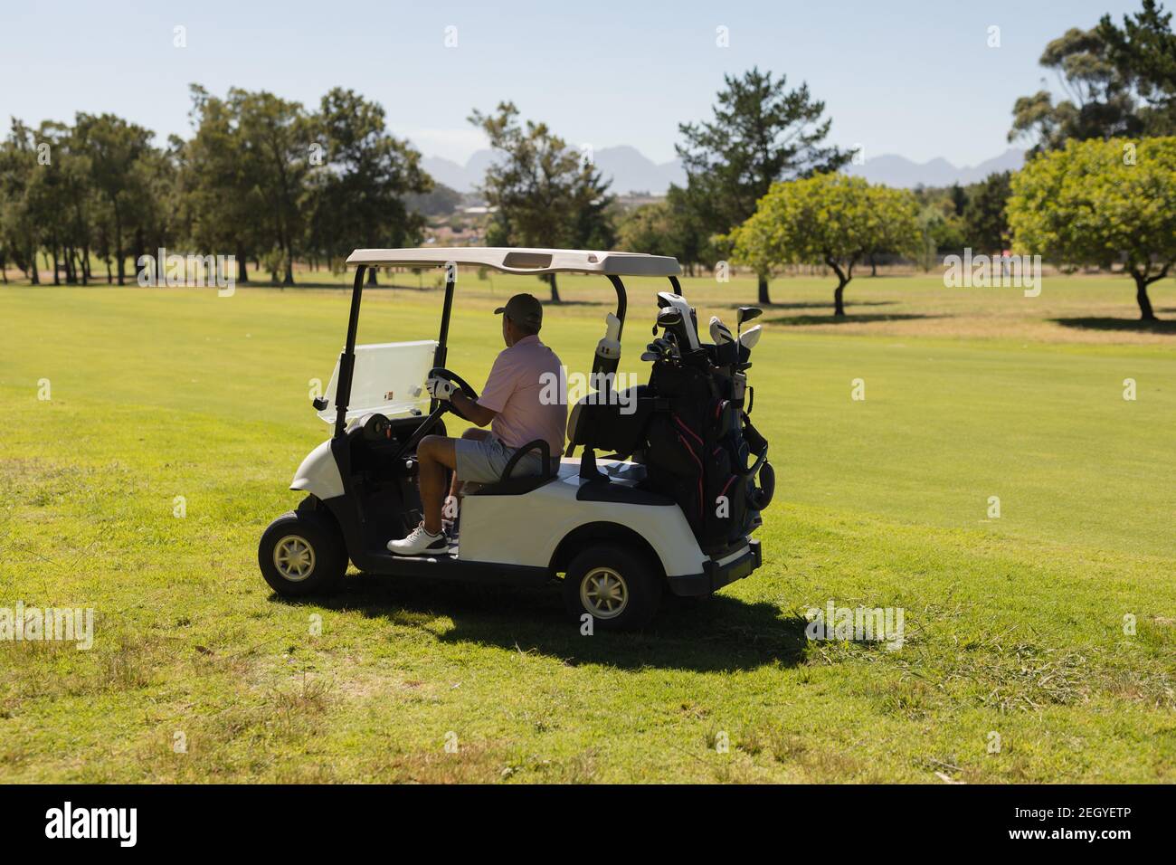 Kaukasischer älterer Mann fährt Golf Buggy auf dem Golfplatz lächelnd Stockfoto