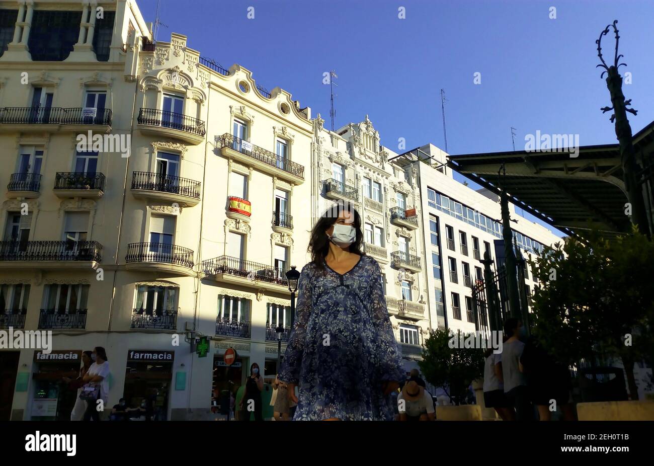 Junge kaukasische spanierin mit lockigen Haaren trägt Schutz Maske Stockfoto