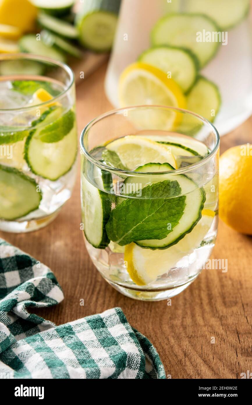 Wasser oder Wasser mit Gurke, Zitrone, Ingwer und Minze auf Holztisch Stockfoto