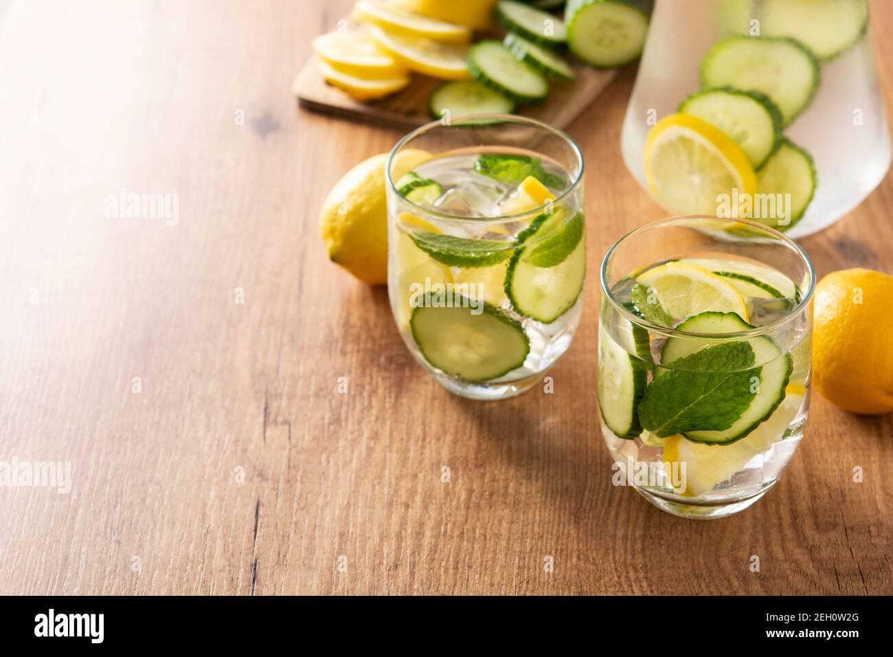 Wasser oder Wasser mit Gurke, Zitrone, Ingwer und Minze auf Holztisch Stockfoto