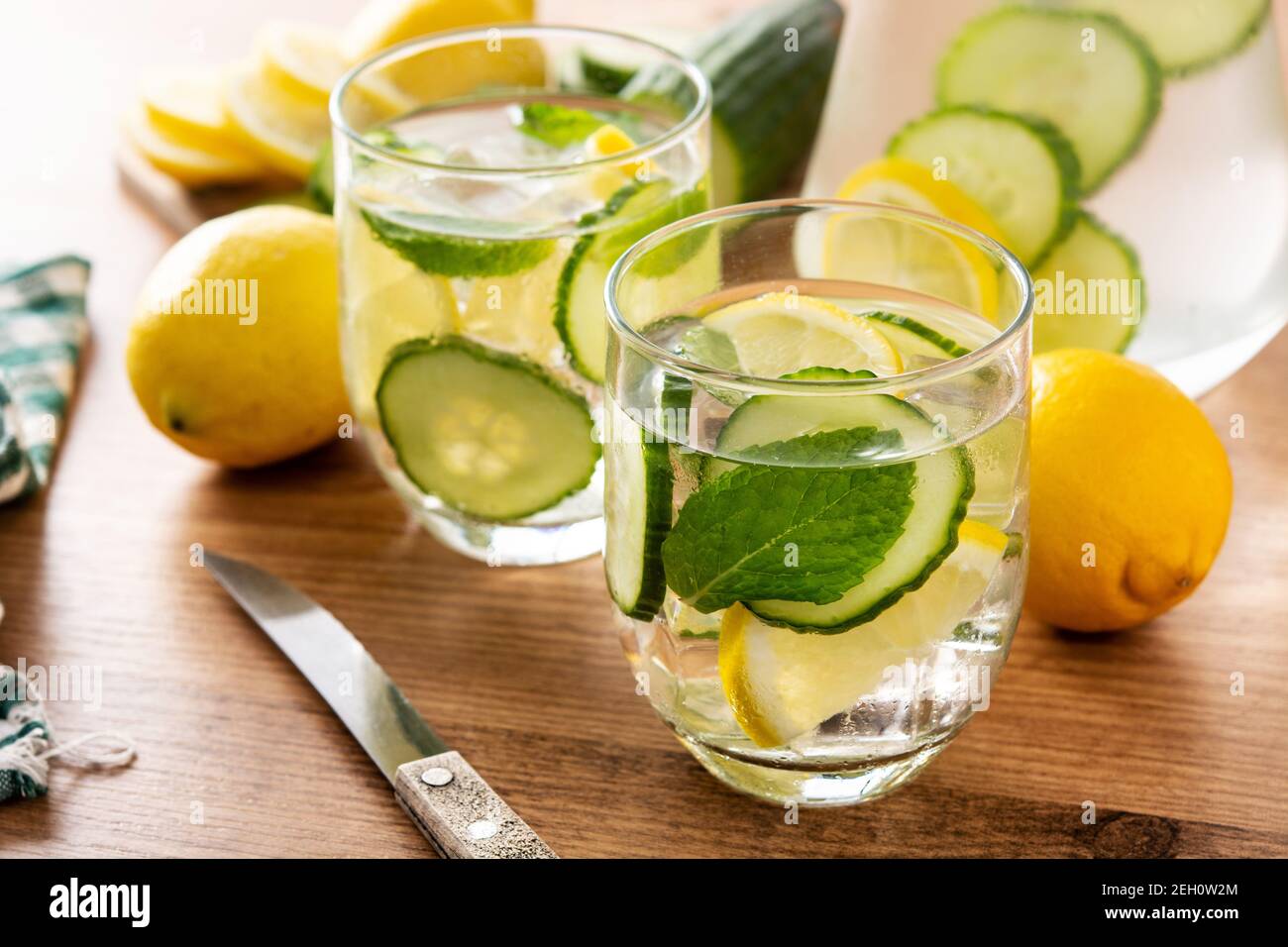 Wasser oder Wasser mit Gurke, Zitrone, Ingwer und Minze auf Holztisch Stockfoto