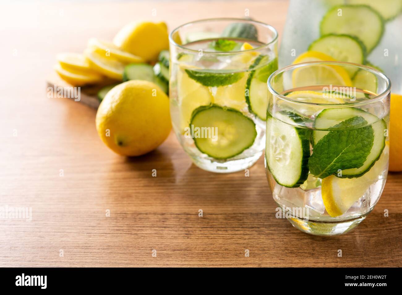 Wasser oder Wasser mit Gurke, Zitrone, Ingwer und Minze auf Holztisch Stockfoto