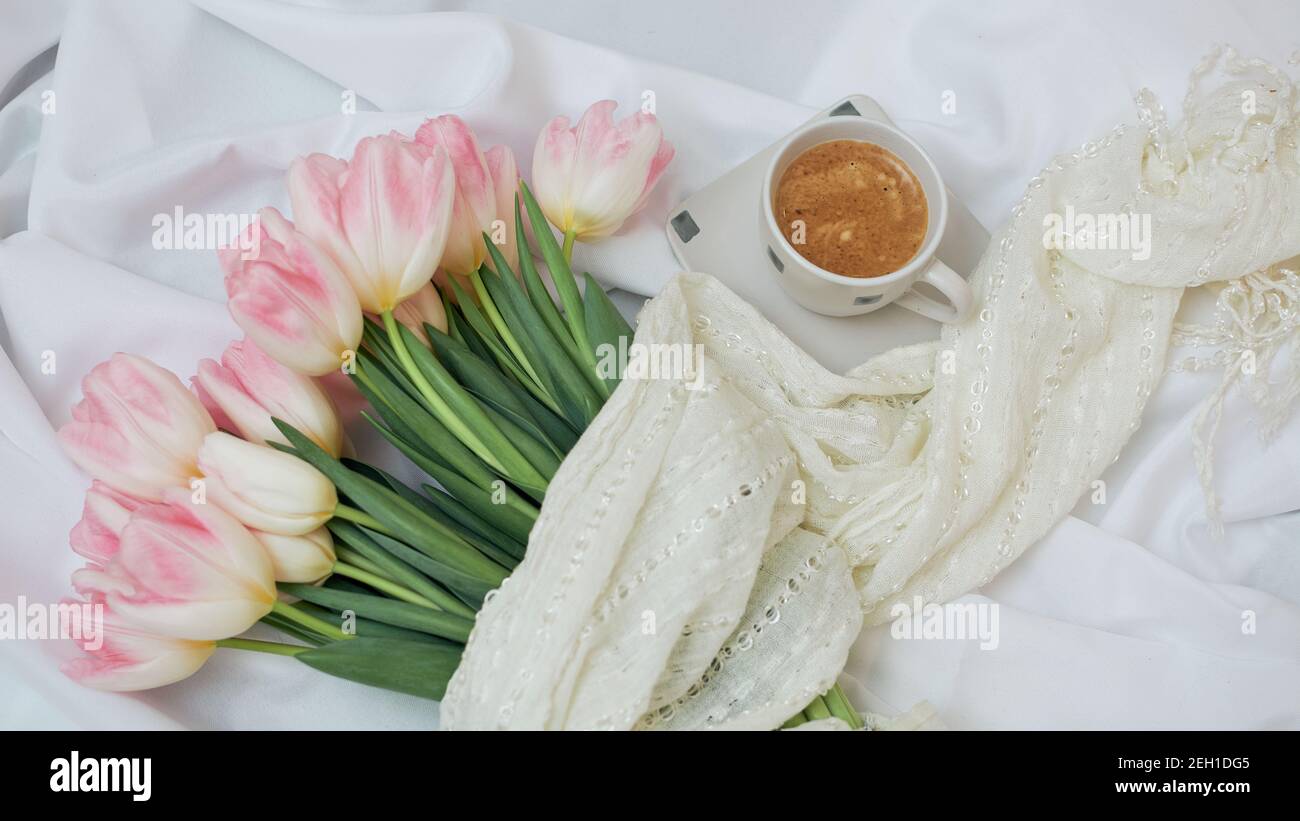 Aromatischer Morgenkaffee in einer weißen Keramikschale. Große schöne Bouquet von Frühlingsblumenblüten. Stockfoto