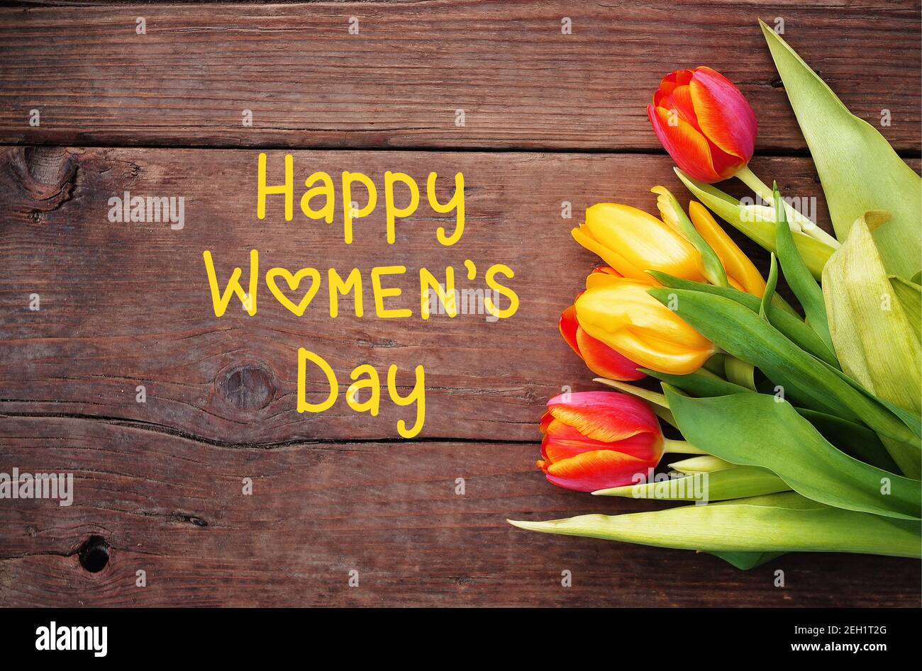Happy Womens Tag Text-Zeichen auf Holz rustikalen Hintergrund mit bunten Tulpen. Internationaler Frauentag schöne Frühlingsblumen Tulpen. Stockfoto