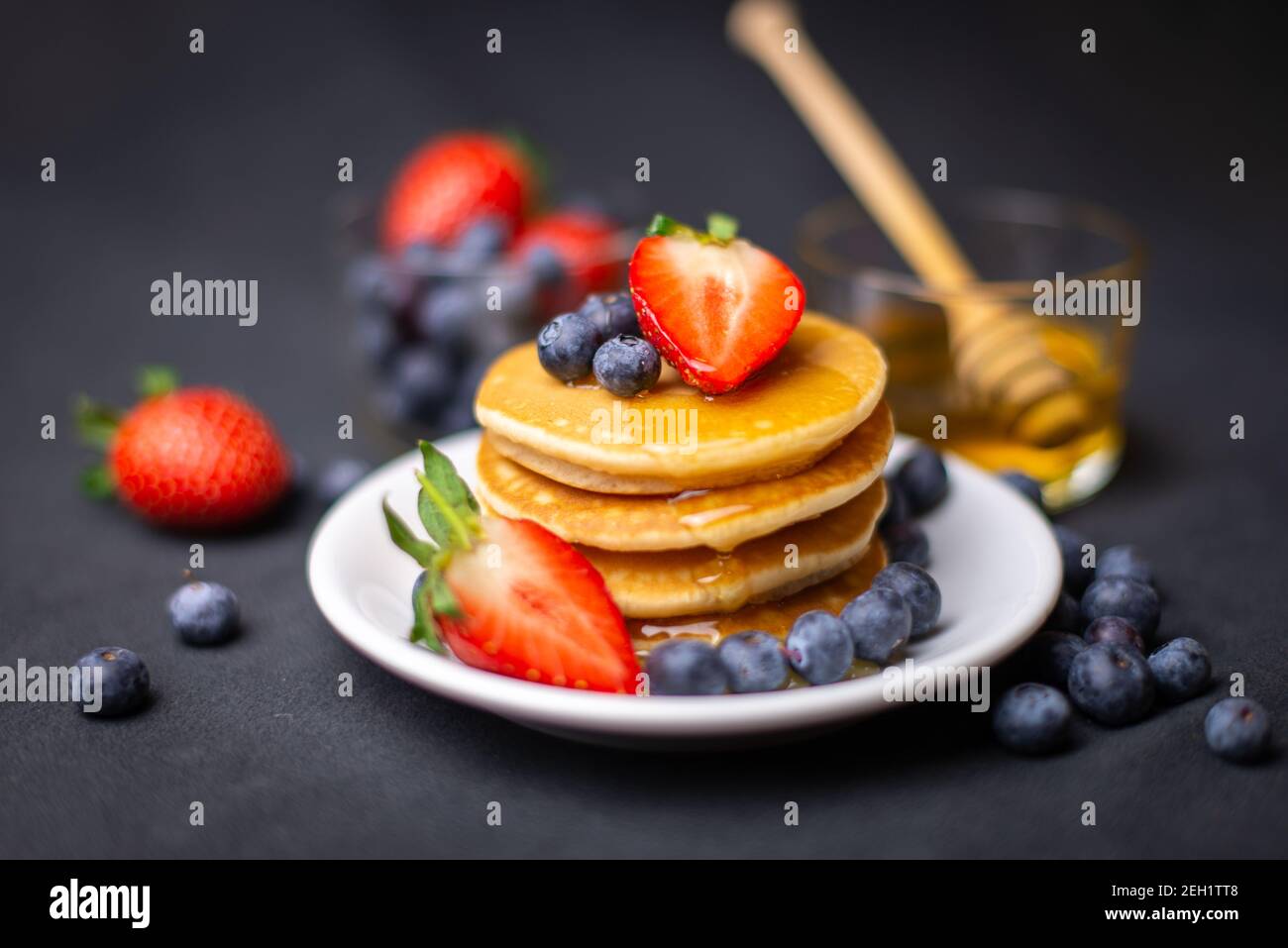 Pfannkuchen mit Erdbeeren, Heidelbeeren und Honig Stockfoto