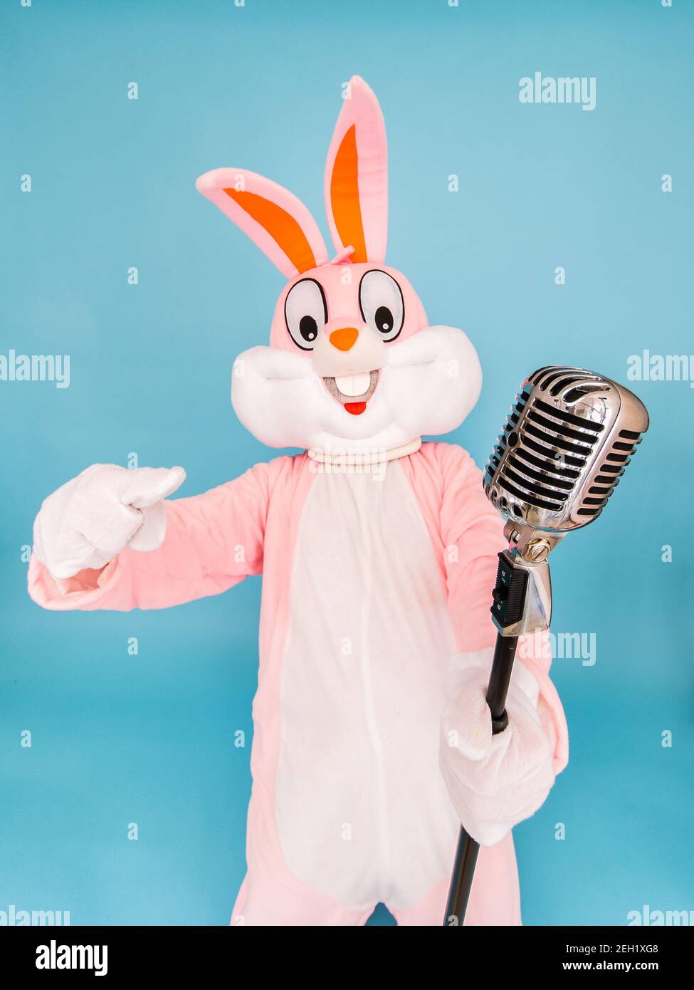 Positive lustige Mann oder Kind Sänger oder Sänger singt Lied zu Retro-Vintage-klassischen Mikrofon. Osterhase oder Kaninchen oder Hase feiert Frohe ostern Stockfoto