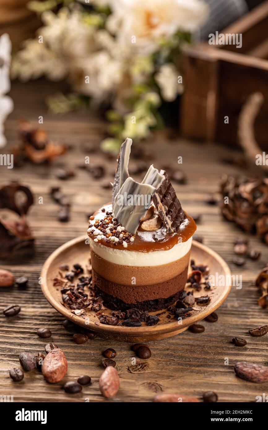 Köstliche Mini runde Schokolade und Kaffee Kuchen in Holzplatte auf Holztisch Hintergrund, Stockfoto