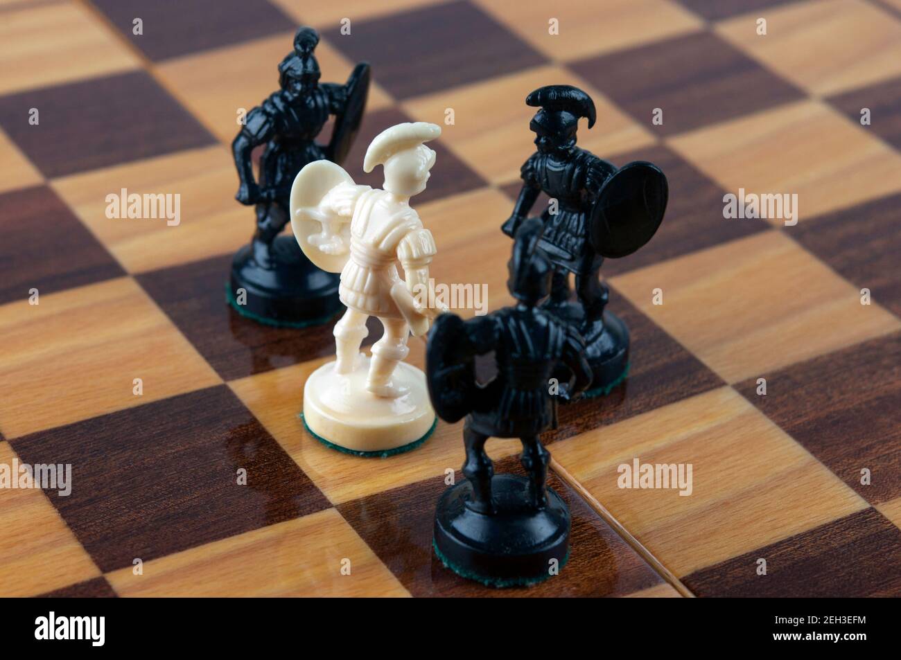 Weiße Bauern gegen schwarze Bauern. Selektiver Fokus auf weißem Bauer. Konzept von einem gegen alle. Konzept von Kraft und Tapferkeit. Stockfoto