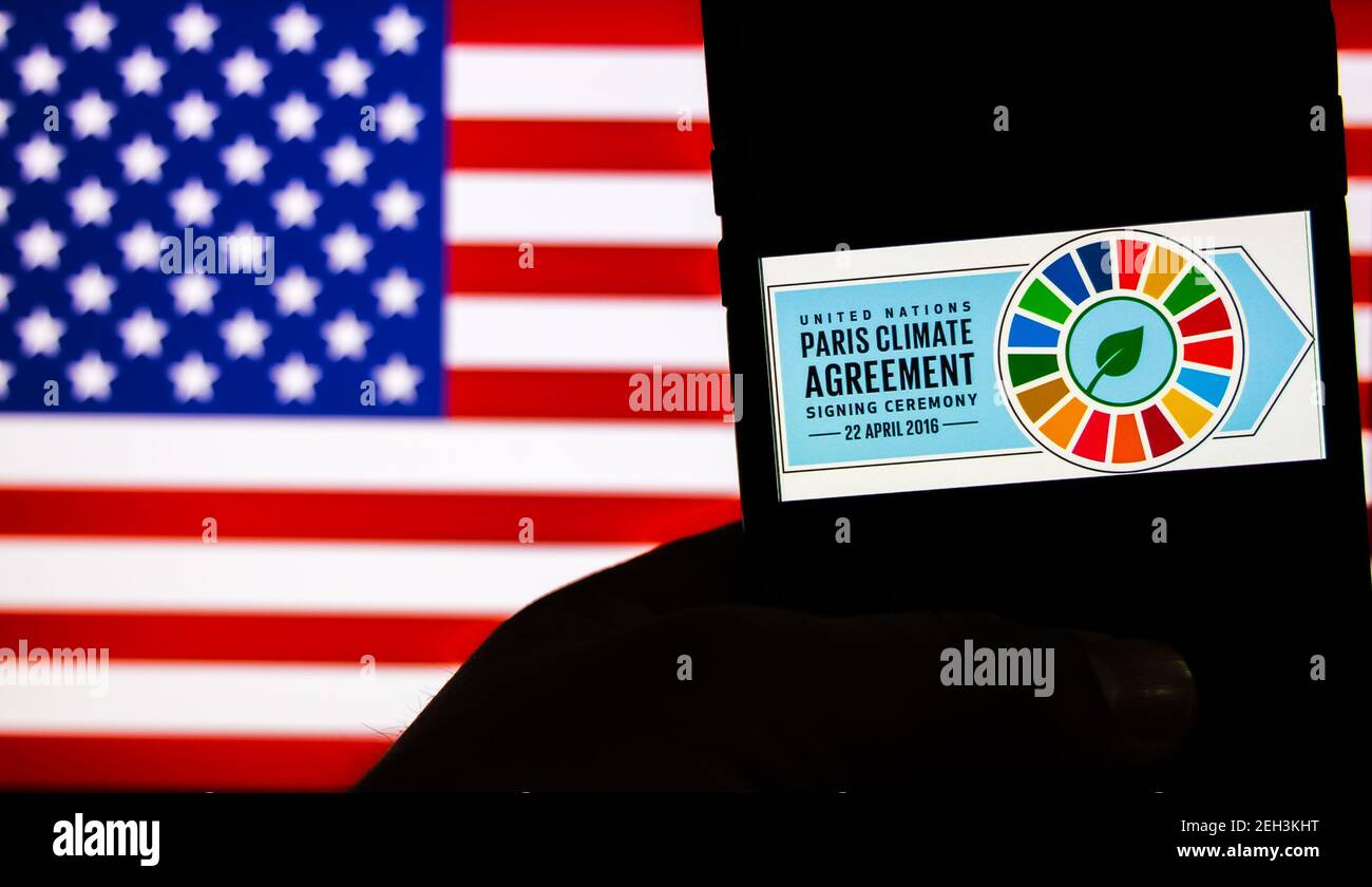 Kathmandu, Nepal - Februar 19 2021: Logo des Pariser Klimaabkommens gegen die Flagge der Vereinigten Staaten von Amerika. USA offiziell wieder in Paris Climat Stockfoto