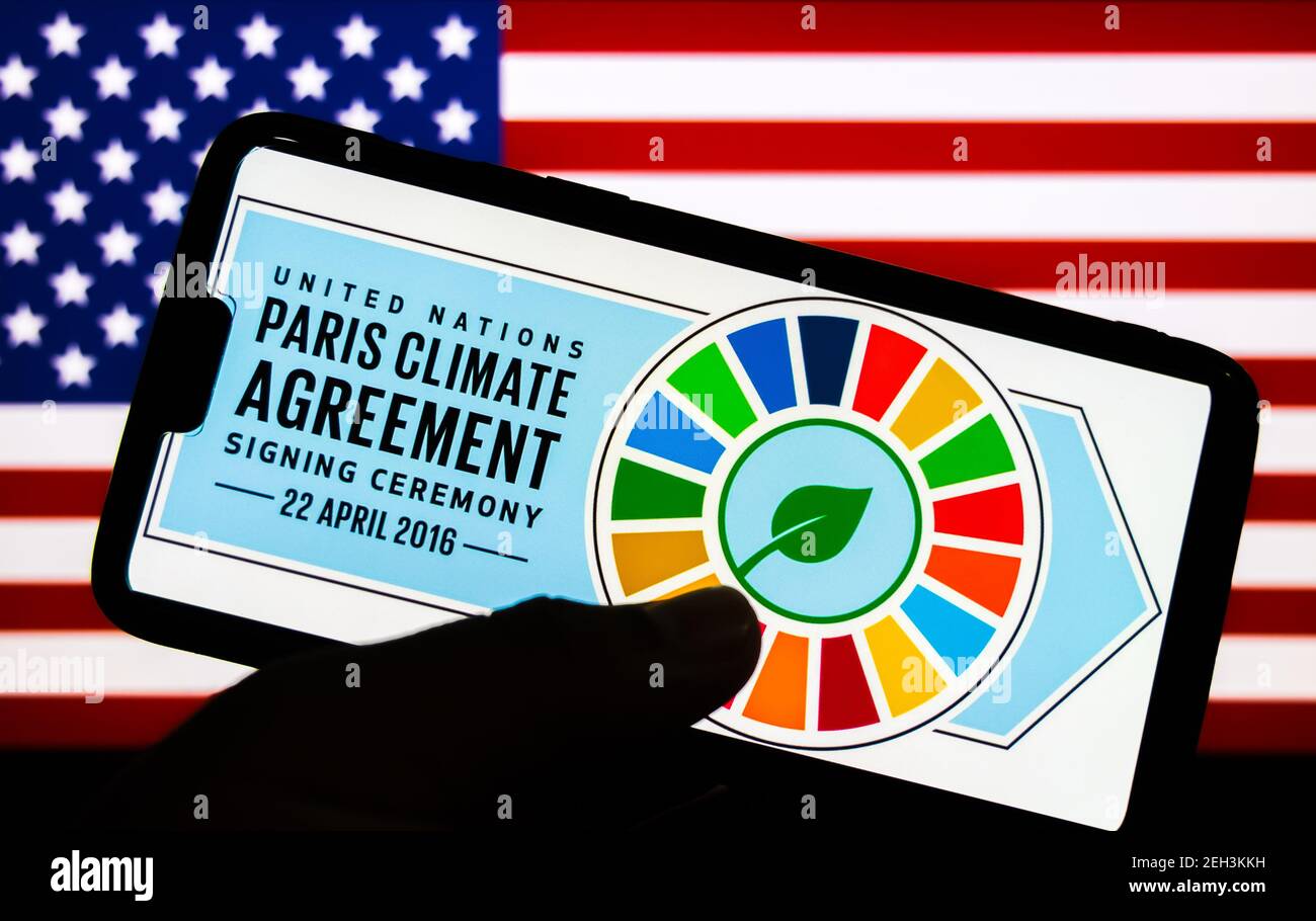 Kathmandu, Nepal - Februar 19 2021: Logo des Pariser Klimaabkommens gegen die Flagge der Vereinigten Staaten von Amerika. USA offiziell wieder in Paris Climat Stockfoto