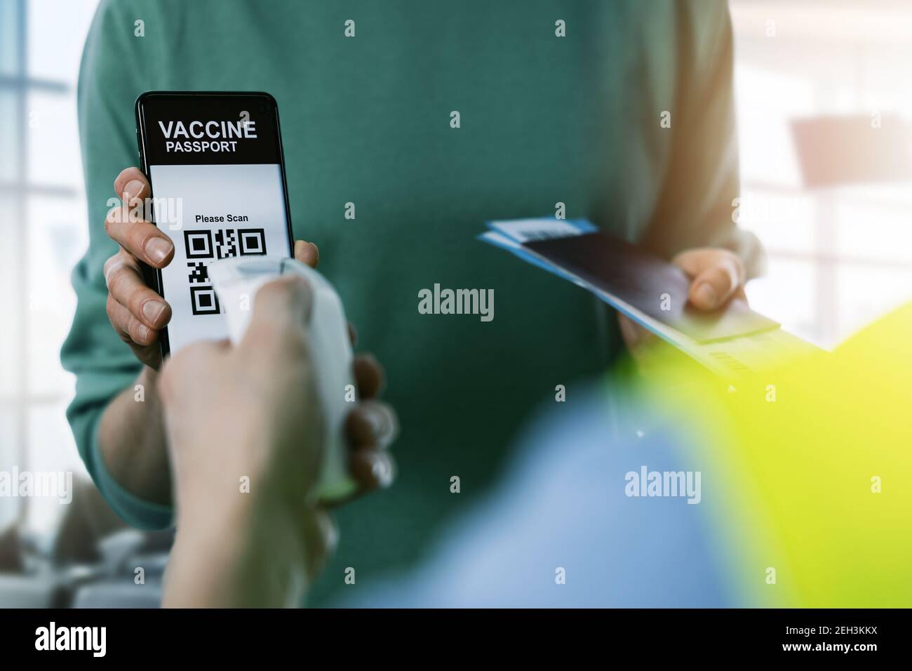 flughafen-Arbeiter Scannen touristischen Impfstoff Pass in Handy. Sichere Reise neu normal Stockfoto