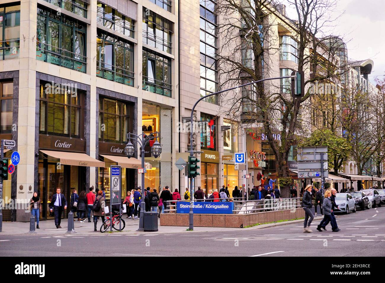 Die belebte Einkaufsstraße Königsallee mit U-Bahn-Schild 'Steinstraße/Königsallee'. Es ist eine der führenden Einkaufsmeilen in Europa. Stockfoto