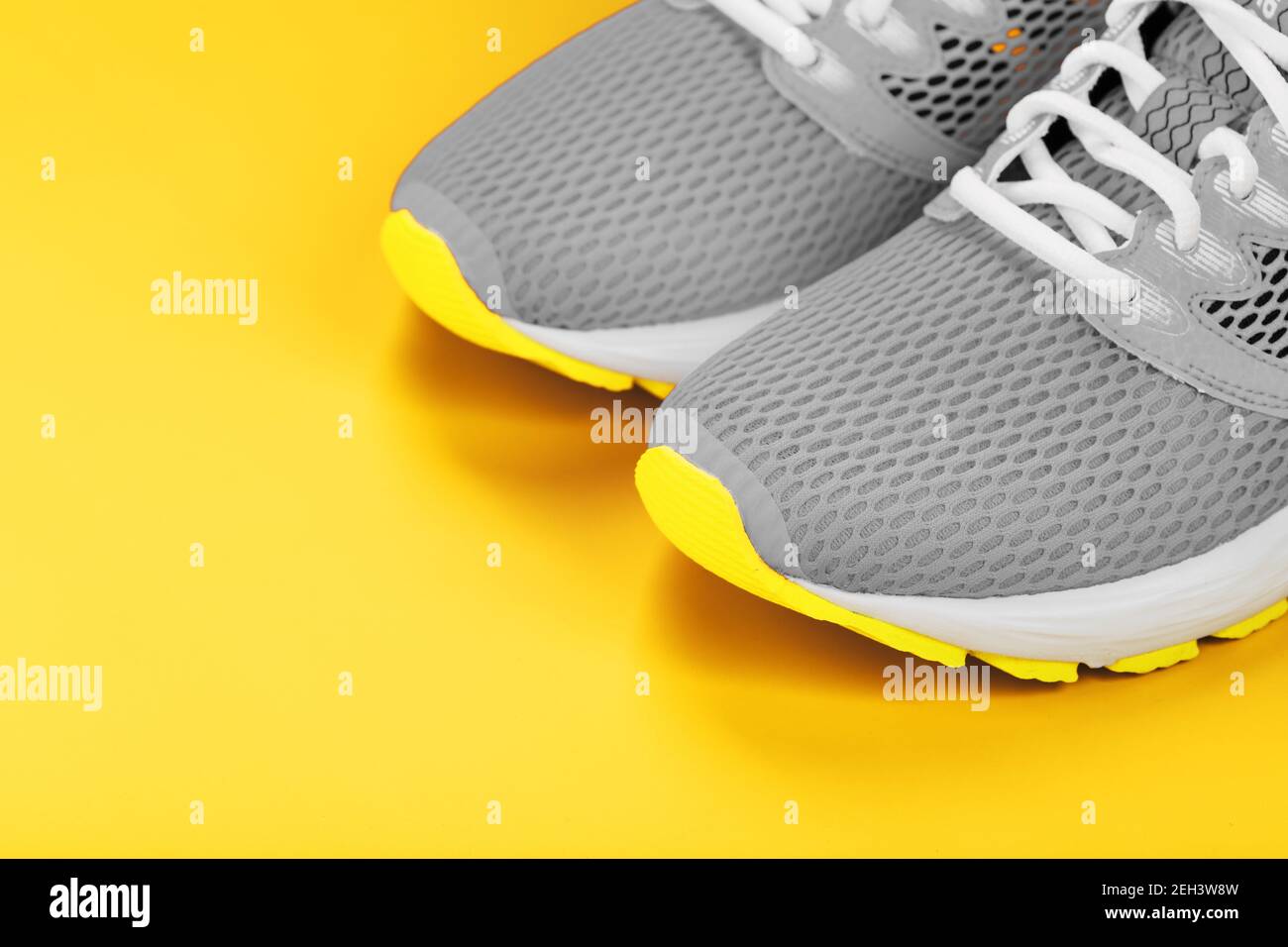 Graue Sneaker auf gelbem Hintergrund Sportkonzept, Freiraum. Freier Speicherplatz Stockfoto