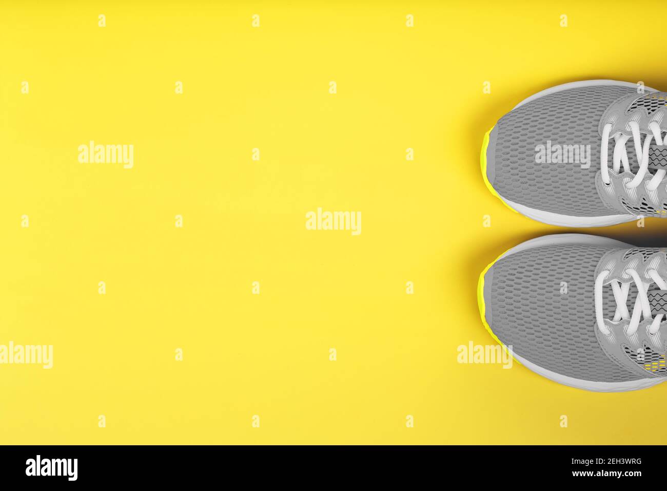 Graue Sneaker auf gelbem Hintergrund Sportkonzept, Freiraum. Freier Speicherplatz Stockfoto