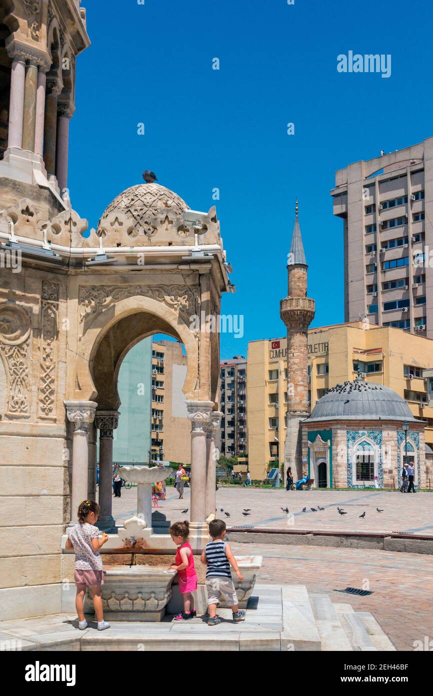 Izmir, Provinz Izmir, Türkei. Konak Square. Die Konak-Moschee vom Uhrturm aus gesehen, der zum Teil auf der linken Seite zu sehen ist, wo drei Kinder pla sind Stockfoto