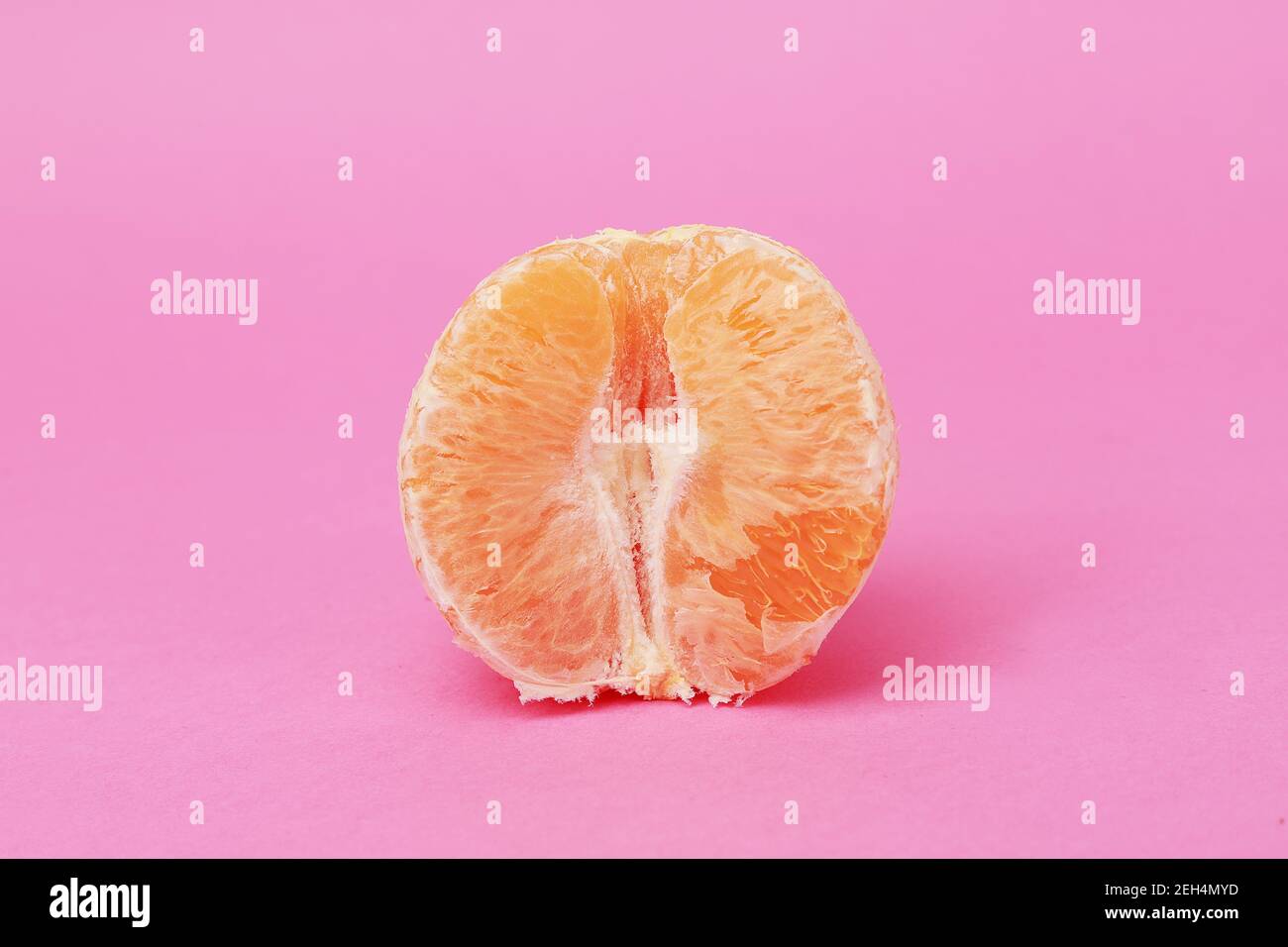 Halb Orange auf pastellfarbenem Hintergrund Stockfoto