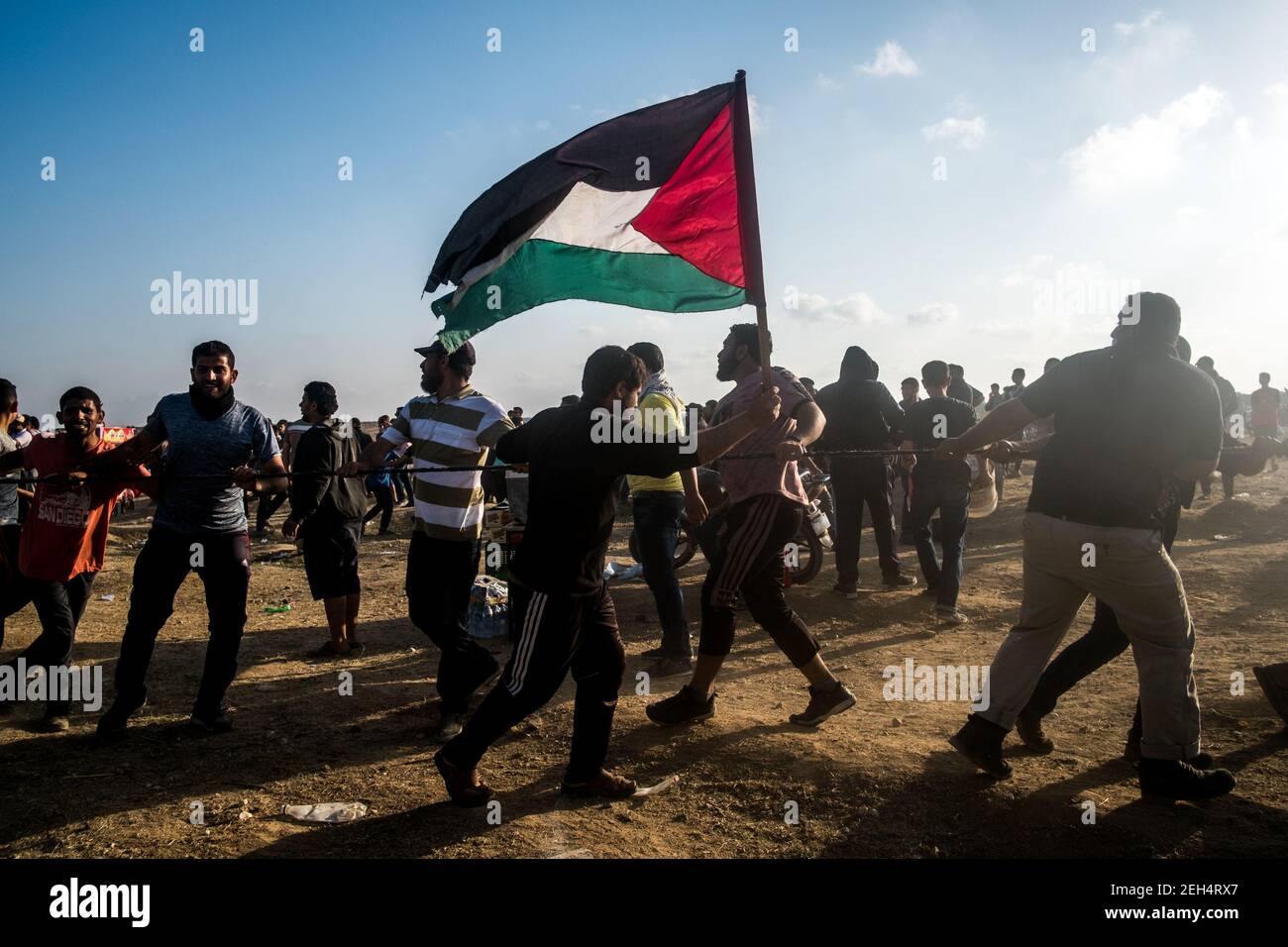 Die Demonstranten laufen mit Stacheldraht, den sie an der israelischen Grenze abgerissen haben. Die Spannungen entlang der Grenze zwischen Gaza und Israel sind hoch, nachdem mehr als einen Monat lang wöchentlich Massenproteste in der Nähe der Barriere stattfanden, bei denen 50 palästinensische Demonstranten getötet und mehr als 1.700 durch israelische Schüsse verletzt wurden. Die Hamas-Führer in Gaza haben versprochen, dass die Märsche fortgesetzt werden, bis die zehnjährige israelische Blockade des Territoriums aufgehoben wird. Die Proteste werden auch am 14. Und 15. Mai erwartet, dem Tag, an dem die Palästinenser Yawm an-Nakba oder den "Tag der Katastrophe" begehen werden, um den Jahrestag ihrer Massenentmachtung zu begehen Stockfoto