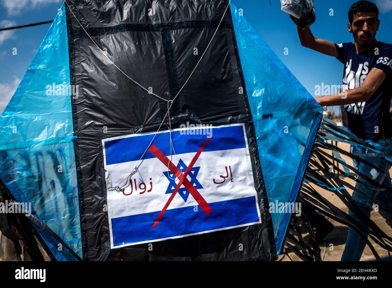 Ein Demonstrator mit einem Drachen, bei dem die israelische Flagge rot durchgestrichen wurde, geht an die Grenze oder eine Massenkundgebung - der große rückmarsch - findet statt. Die Demonstranten fordern das Recht auf Rückkehr in den isrealen Boden, aus dem sie vor 70 Jahren vertrieben wurden. 14.Mai 2018. Malaka. Gaza-Streifen. Palästina. Stockfoto