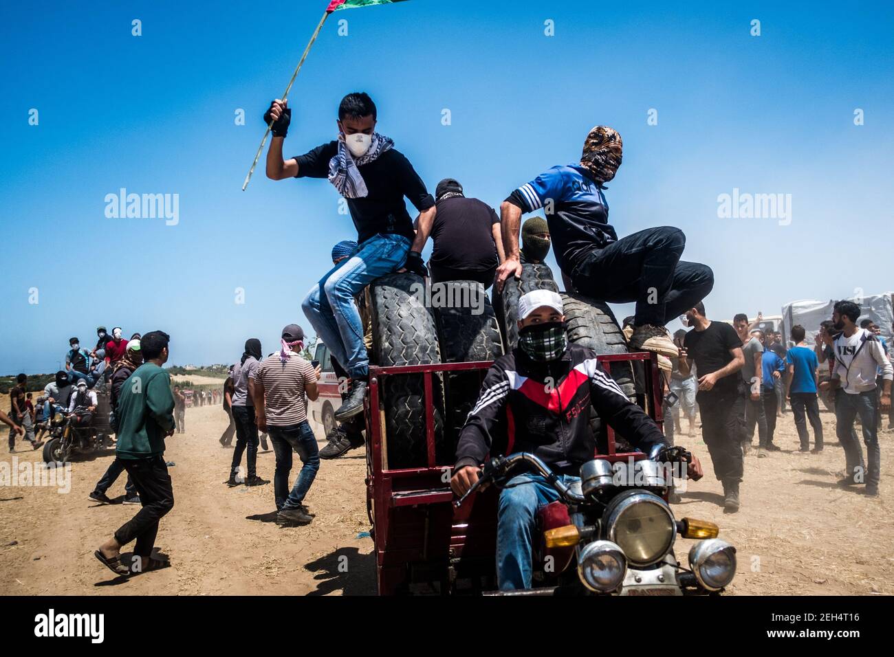 Männer auf Motorrädern mit brennenden Reifen bei einer Demonstration organisiert, um den 70th. Jahrestag der Nakba, auch bekannt als der Tag der Katastrophe im Jahr 1948, und gegen US-Pläne, die US-Botschaft nach Jerusalem zu verlegen. 14.Mai 2018. Malaka. Gaza-Streifen. Palästina. Stockfoto