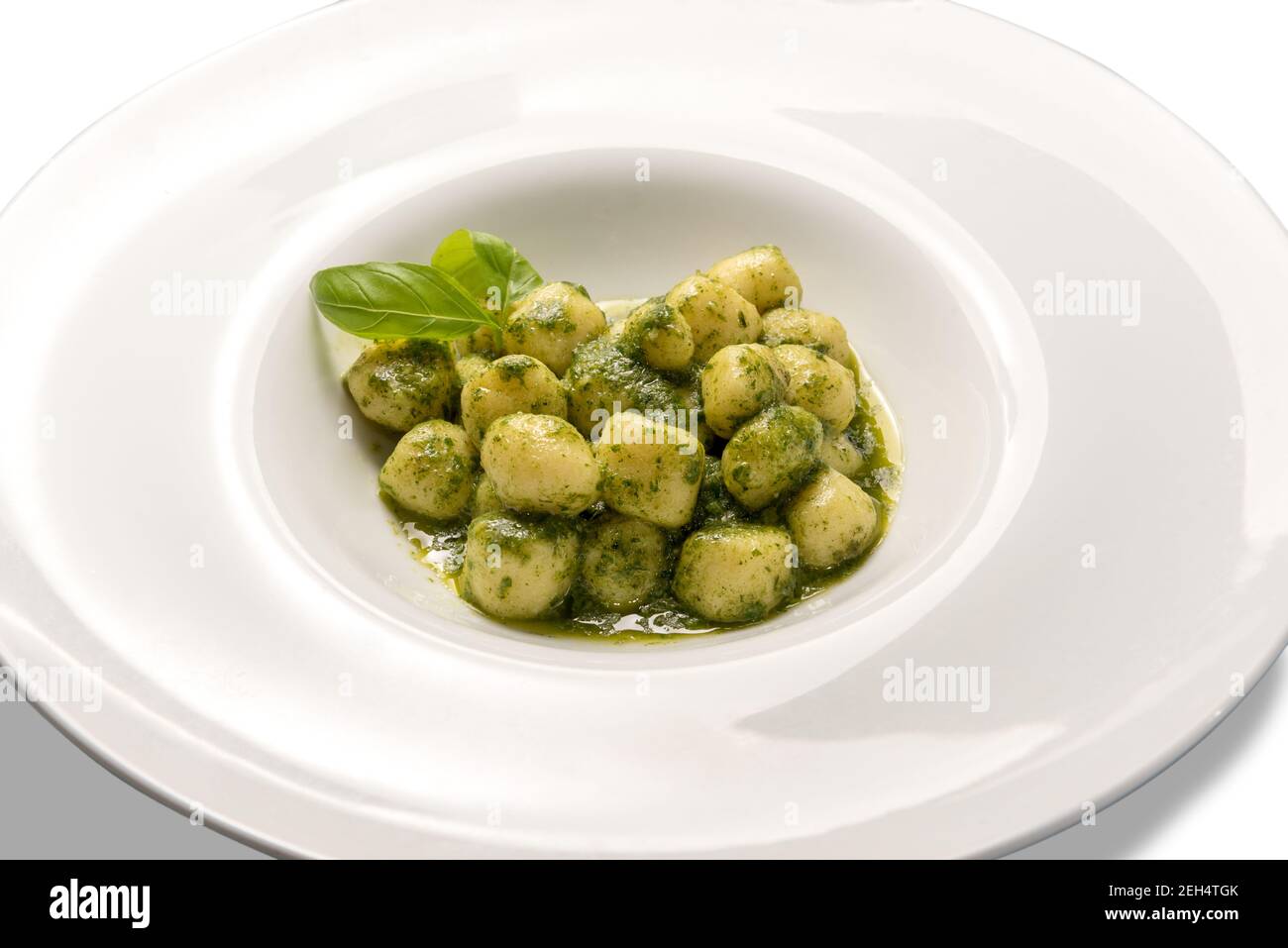 Gnocchi al Pesto aus Genua, traditionelles italienisches Rezept aus frischem Basilikum, Olivenöl, Pinienkernen. In weißen Schale isoliert auf weiß Stockfoto