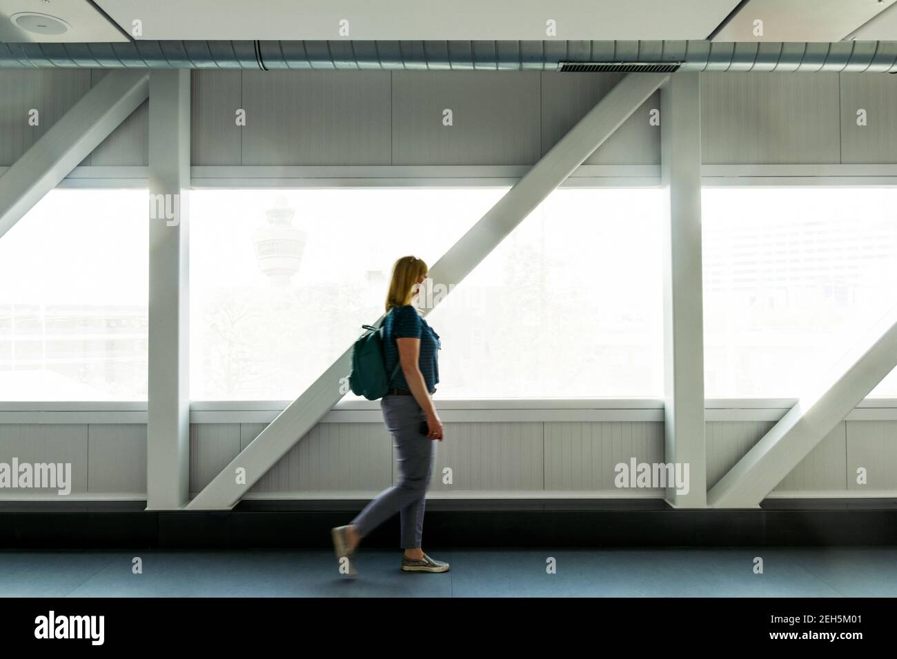Reisende Frau trägt KN95 FFP2 Gesichtsmaske am Flughafen vor Virus und Smog zu schützen. Neues Normal-, Reise- und Coronavirus-Konzept. Stockfoto