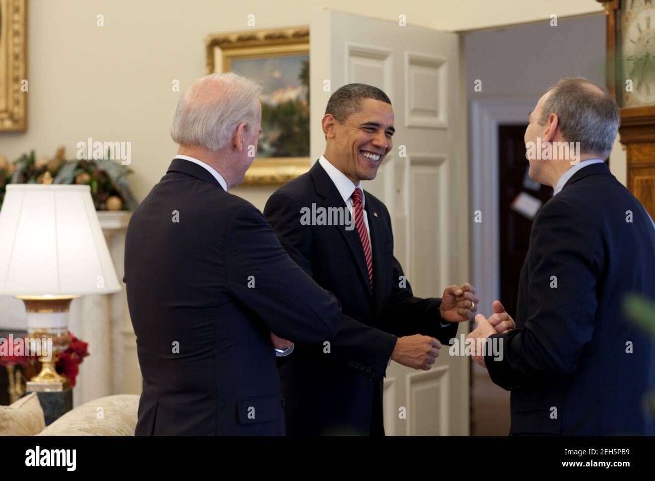 Präsident Barack Obama, Vizepräsident Joe Biden, und Phil Schiliro, Assistent des Präsidenten für legislative Angelegenheiten, sprechen im Oval Office am 24. Dezember 2009, nachdem der US-Senat die Reform der Krankenversicherung verabschiedet hatte. Stockfoto