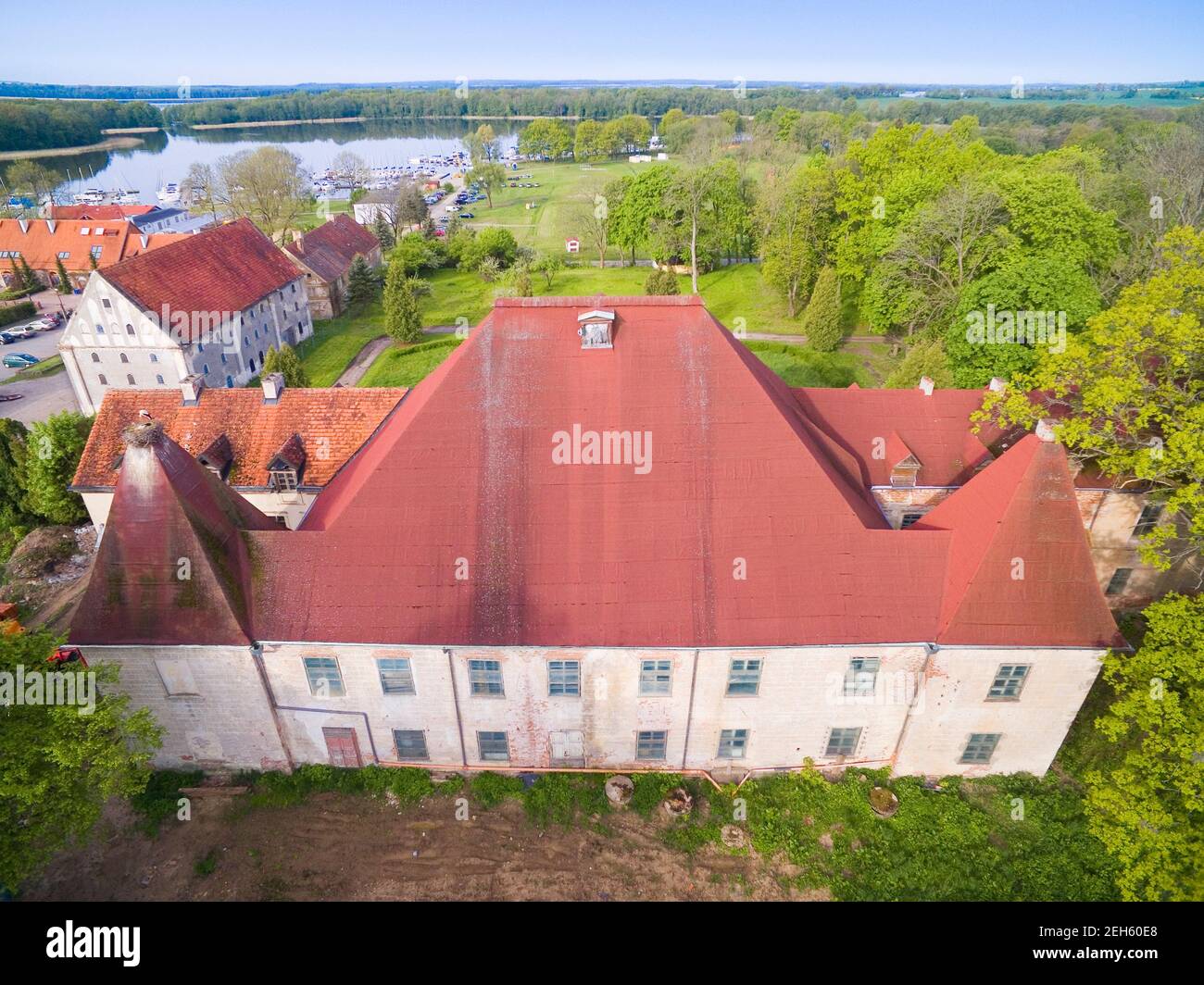 Ruinierter Barockpalast in Sztynort, Polen (ehemals Steinort, Ostpreußen). Sztynorckie See und Yachten in Marina im Hintergrund vertäut Stockfoto
