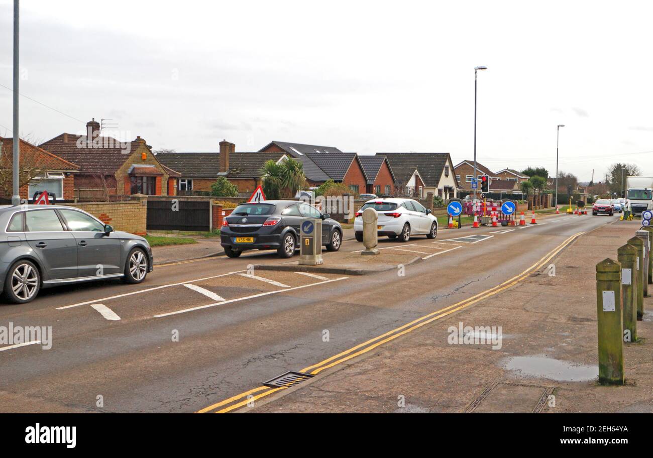 Fahrzeuge, die bei Ampelkontrolliertem Straßenbau Schlange stehen und ein einziges Dateisystem in Hellesdon, Norfolk, England, Großbritannien betreiben. Stockfoto