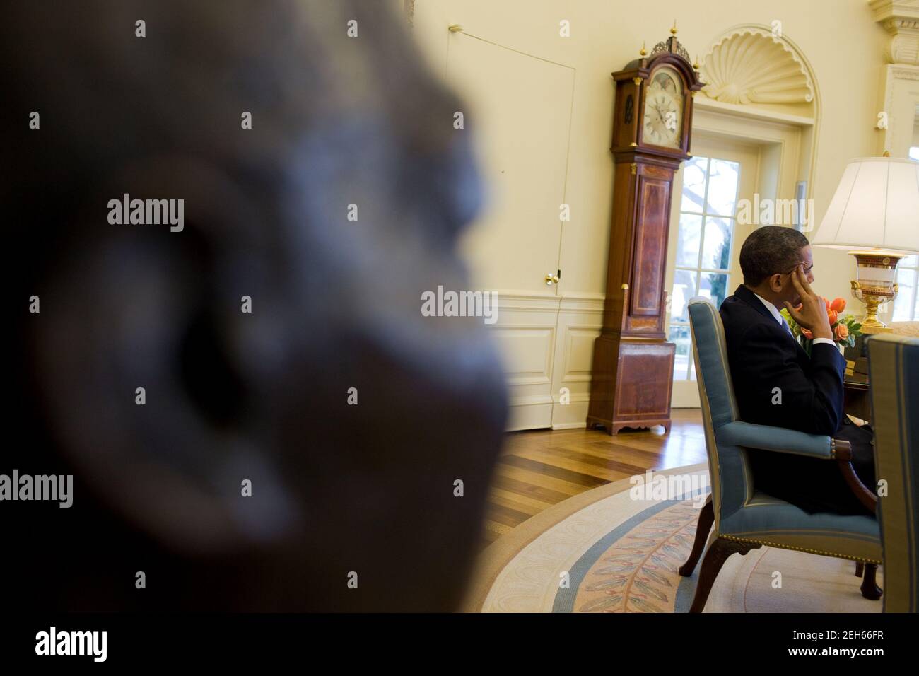 Eine Bronzebüste von Dr. Martin Luther King, Jr. ist im Vordergrund zu sehen, als Präsident Barack Obama mit hochrangigen Beratern zusammentritt, im Oval Office, 4. Februar 2010. Stockfoto