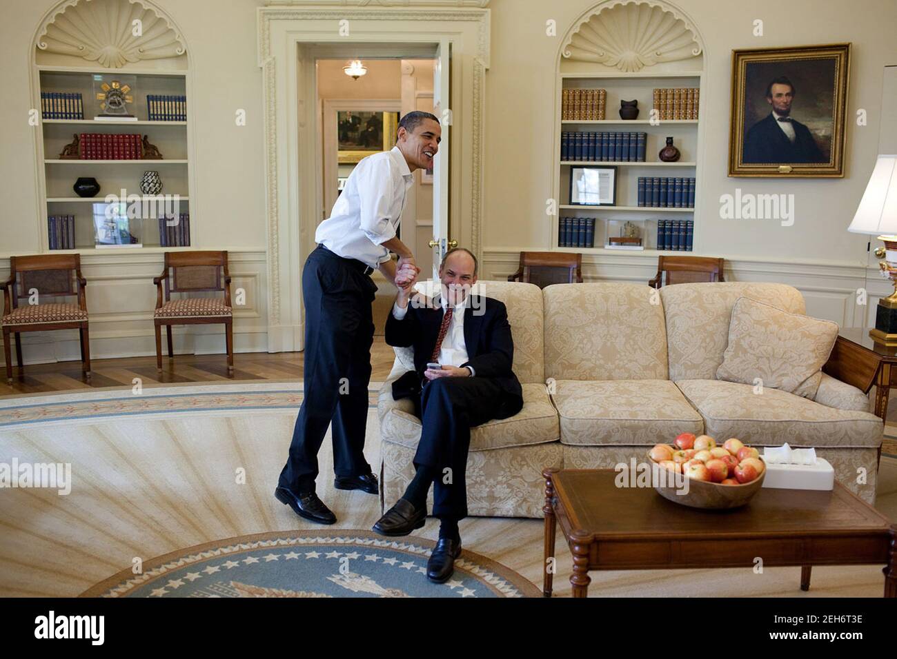 Präsident Barack Obama schüttelt die Hände mit Phil Schiliro, dem Assistenten des Präsidenten für Legislative Angelegenheiten, im Oval Office, nachdem er erfahren hatte, dass ein Kongressmitglied am 21. März 2010 ein Ja zur Gesundheitsreform erhalten hatte. Stockfoto