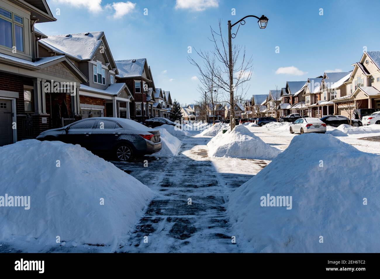 Entlang der Straße, neben dem Bürgersteig von Schnee befreit, gibt es ordentlich Rutschen von Schnee Stockfoto