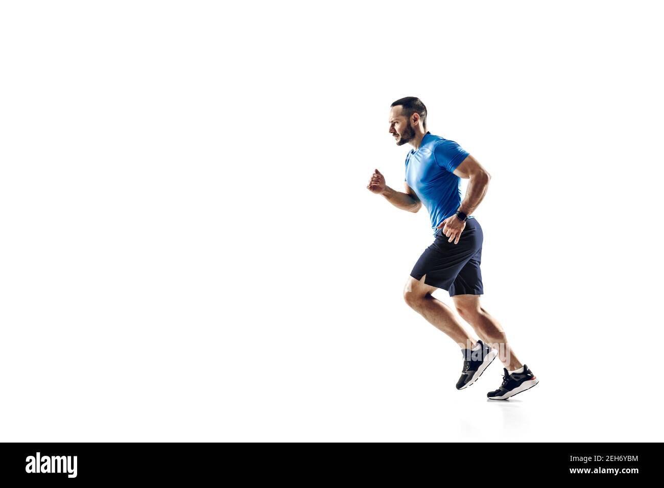 Zweck. Kaukasischer Profi-Athlet, Läufertraining isoliert auf weißem Studio Hintergrund. Muskulöser, sportlicher Mann. Konzept von Aktion, Bewegung, Jugend, gesunder Lebensstil. Copyspace für Werbung. Stockfoto