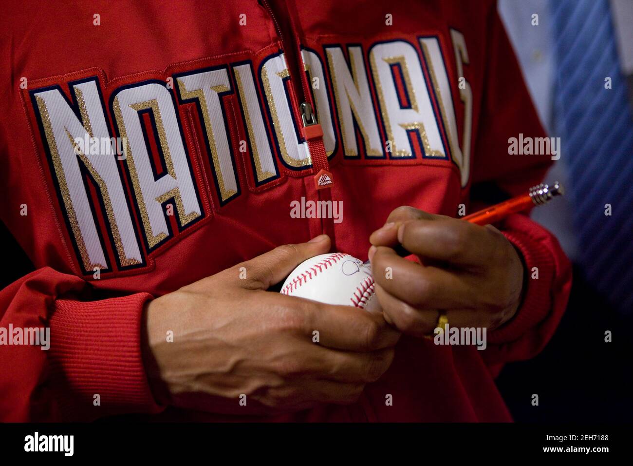 Präsident Barack Obama unterschreibt ein Baseball, nachdem er am Eröffnungstag der Baseballsaison im Nationals Park in Washington, D.C., den 5. April 2010 den feierlichen ersten Pitch ausgeworfen hat. Stockfoto