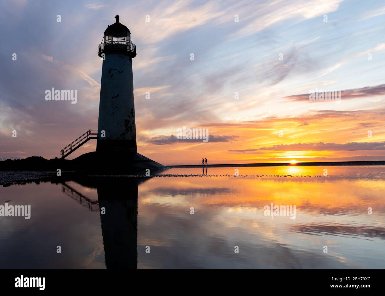 Leuchtturm steht im Pool von Wasser atemberaubende Sonnenuntergang Sonnenaufgangsreflexion Spiegelt sich in Wasser und Meer Schritte Gebäude Nord-Wales Strand am Meer Stockfoto