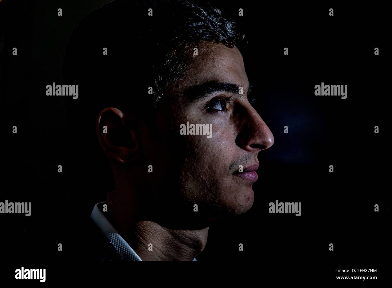 Arabischer Kerl im dunklen Raum mit Licht auf seinem Gesicht Und schöne Schatten Stockfoto