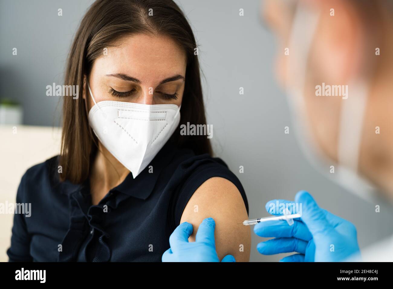 Covid-Impfstoff Injektion Von Arzt In Gesichtsmaske Stockfoto