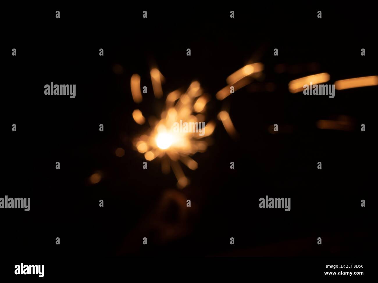 Schwache Funken aus dem Feuer vor dem Schwarzen Hintergrund Stockfoto