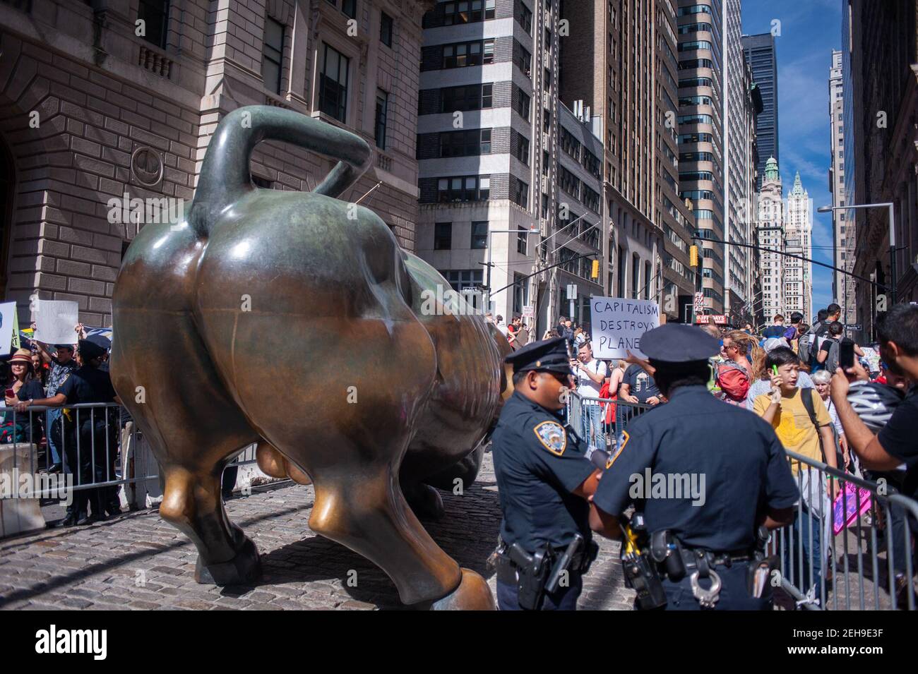 New York, USA. 20th Sept. 2019. Polizeibeamte schützen die Wall Street Bull Statue am Broadway während des Jugendklimperstreiks. Stockfoto