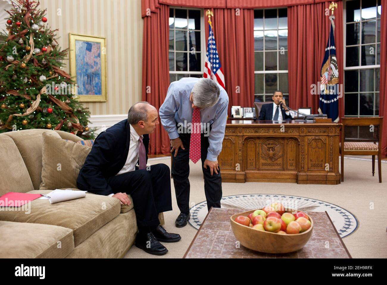 Interim-Stabschef Pete Rouse und Phil Schiliro, Assistent des Präsidenten für Legislative Angelegenheiten, sprechen während Präsident Barack Obama telefoniert mit dem Mehrheitsführer des Senats, Harry Reid, im Oval Office, 16. Dezember 2010. Stockfoto